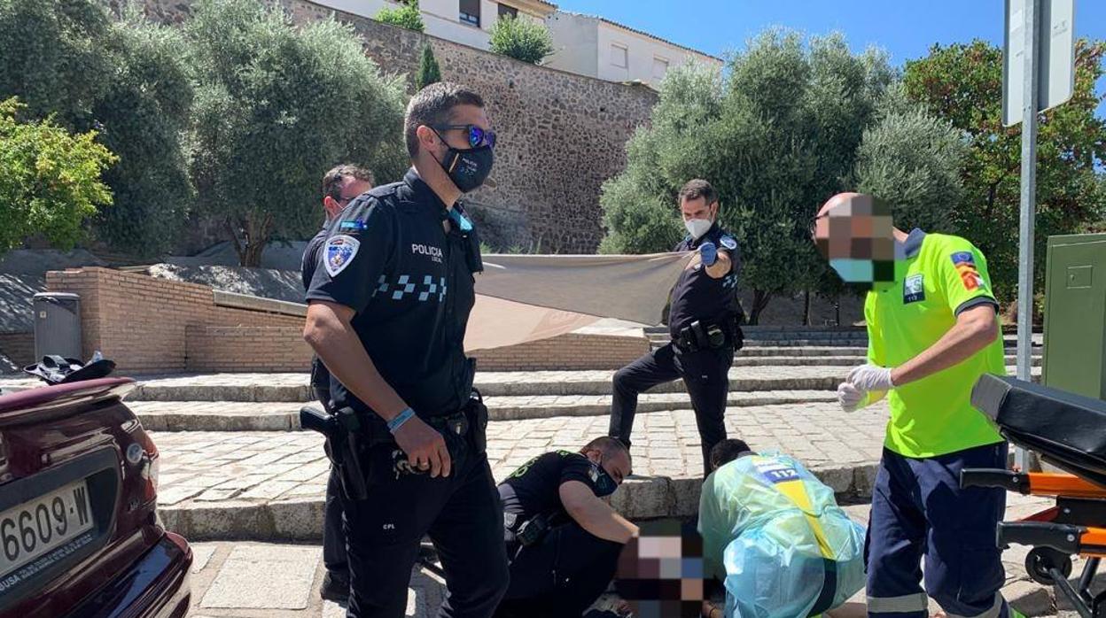 Los agentes atendiendo a la joven en la calle Carrera, junto a la muralla