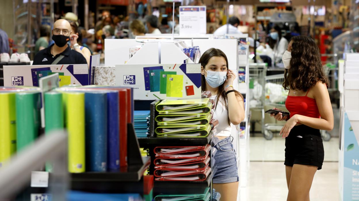 Jóvenes en una tienda de material escolar antes de la vuelta a las aulas