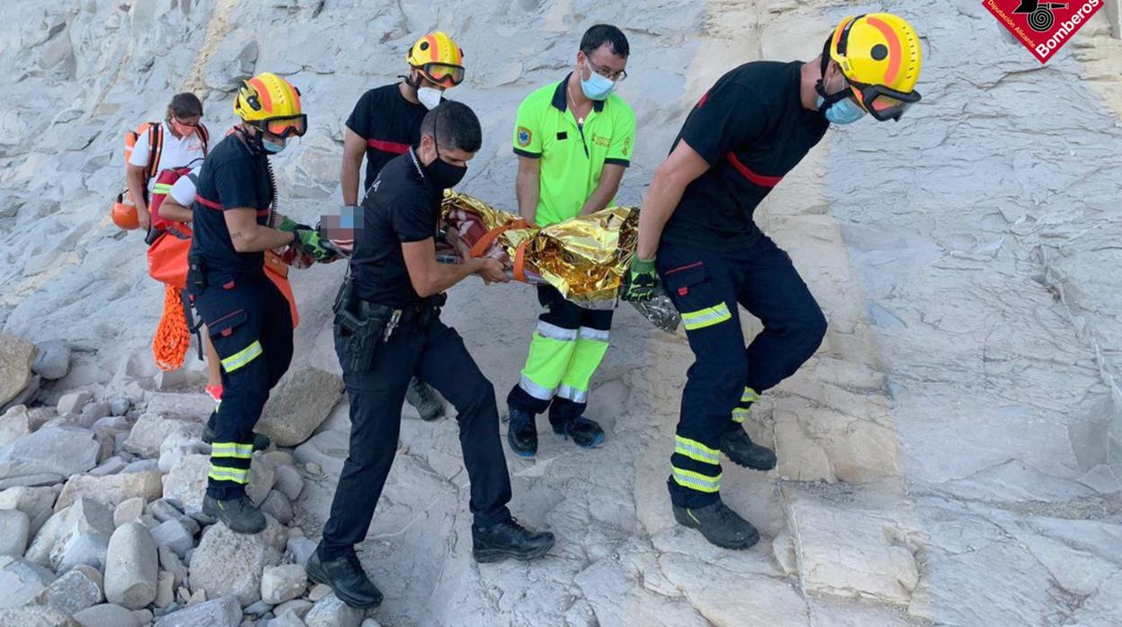 Efectivos de Bomberos rescatando a una mujer en una cala de Benissa