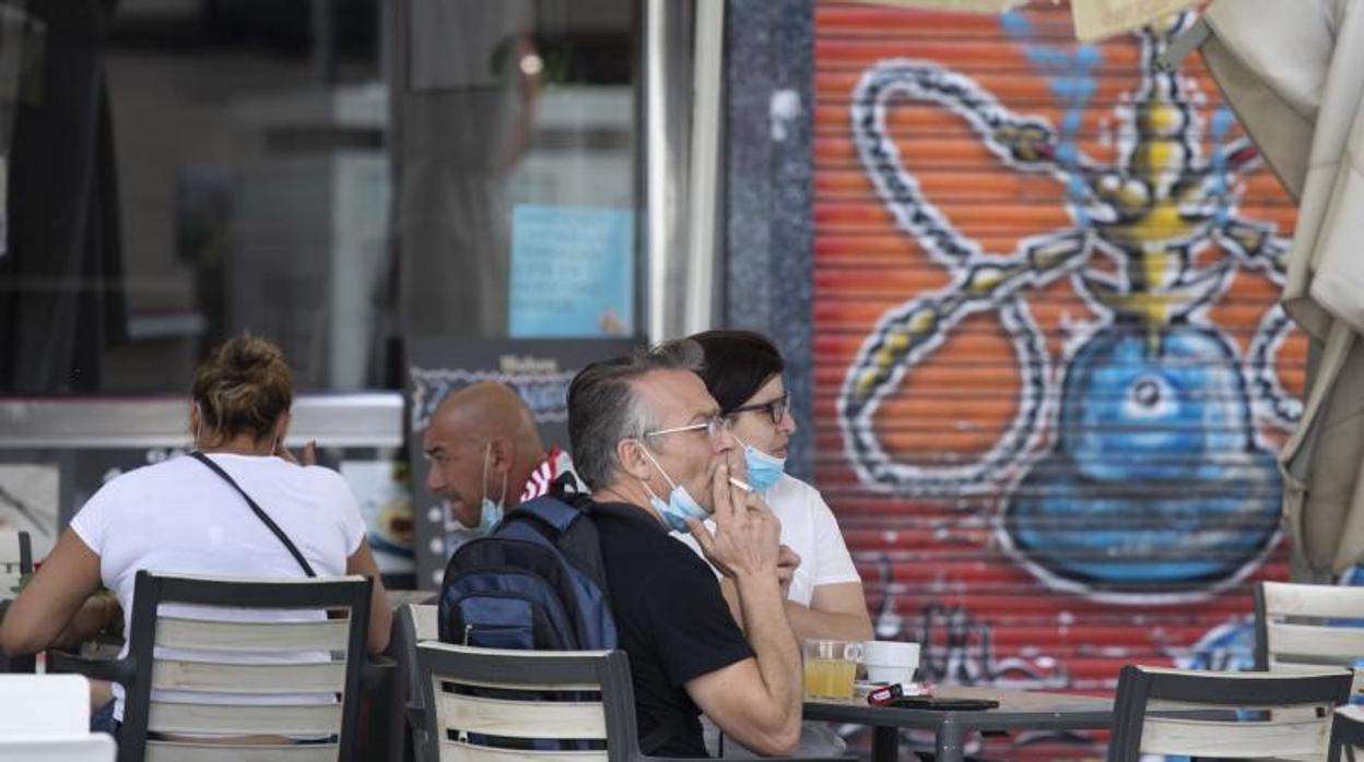 Varios clientes de una terraza de Madrid, frumando