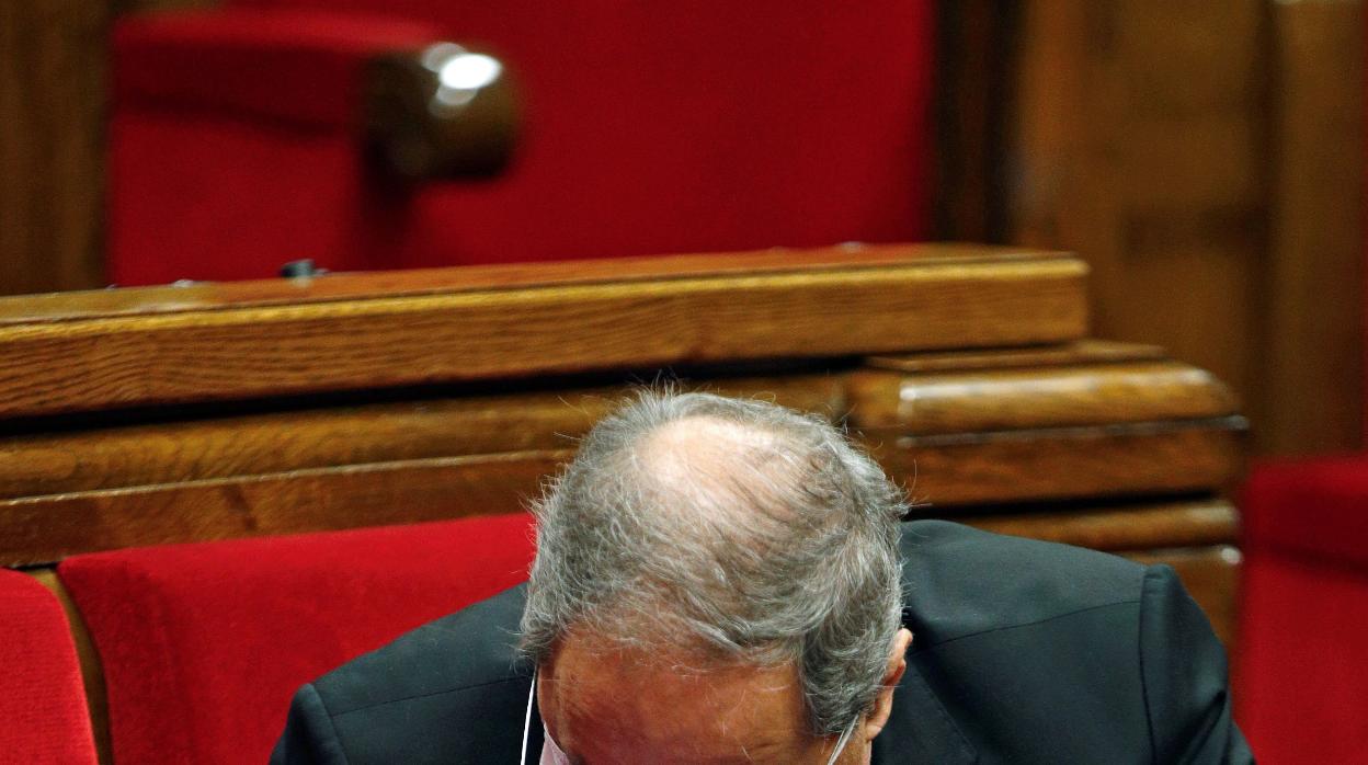 El presidente catalán mira su teléfono durante la sesión parlamentaria de este miércoles