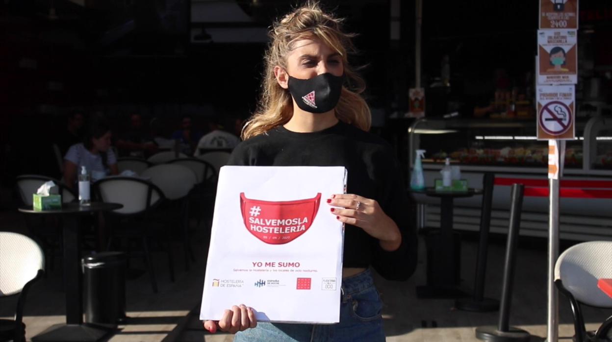 Una profesional de la hostelería con el cartel de la protesta convocada para este miércoles en toda España