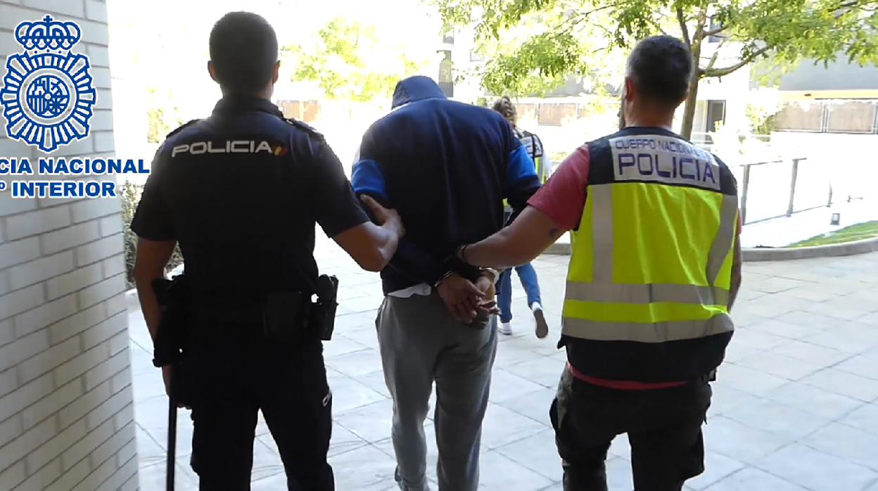 El joven arrestado es conducido por los agentes hacia el vehículo policial