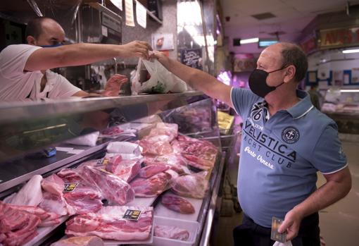 Un carnicero atiendo a un cliente en el mercado de Usera