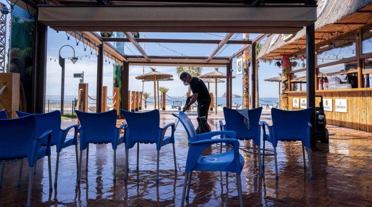 Un hostelero limpia su establecimiento en Benidorm