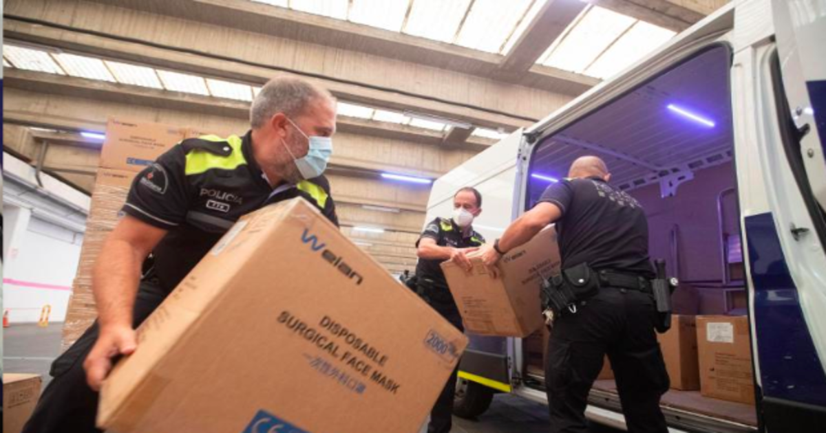 Agentes de la policía local de Barcelona recogen y cargan cajas con mascarillas entregadas por el Gobierno a la Diputación de Barcelona y el Ayuntamiento de la capital catalana, hoy