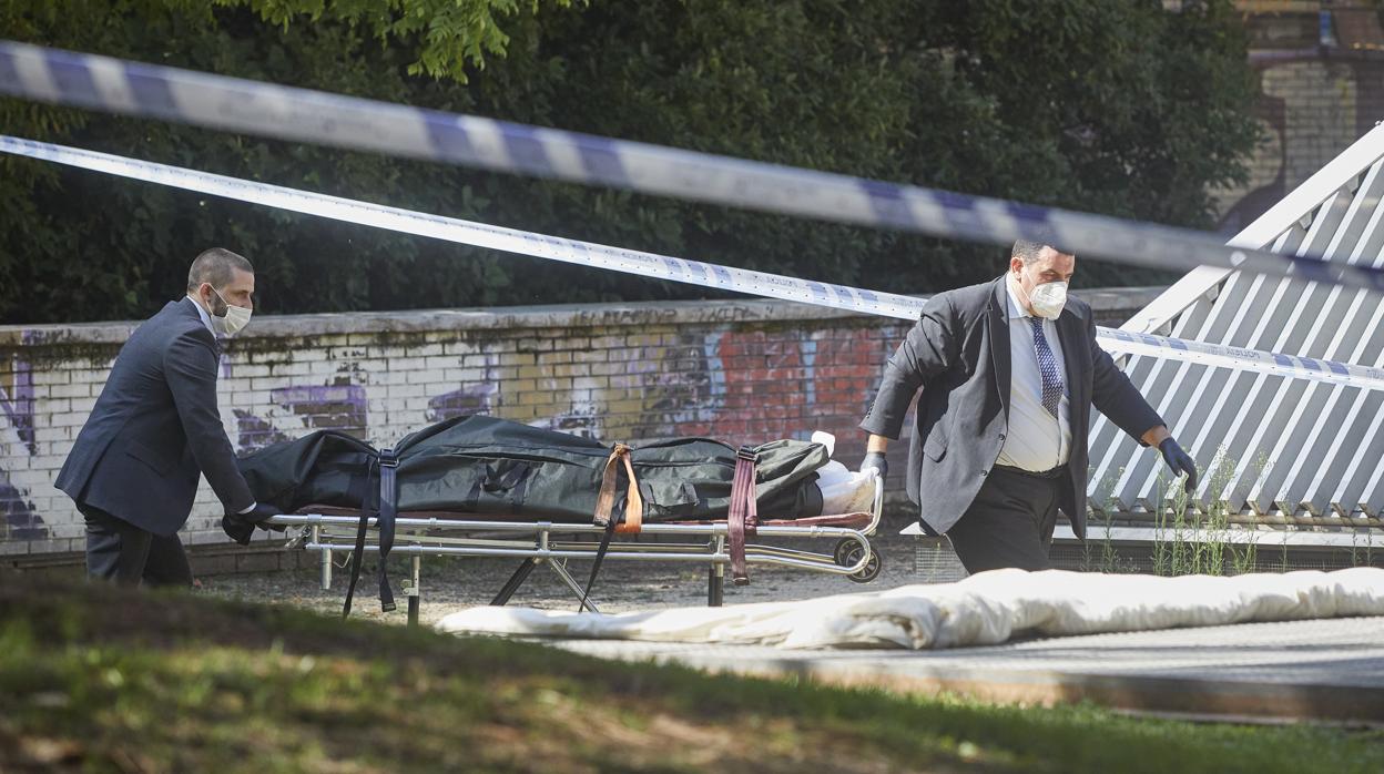 Los servicios funerarios retiran ayer el cadáver de la mujer