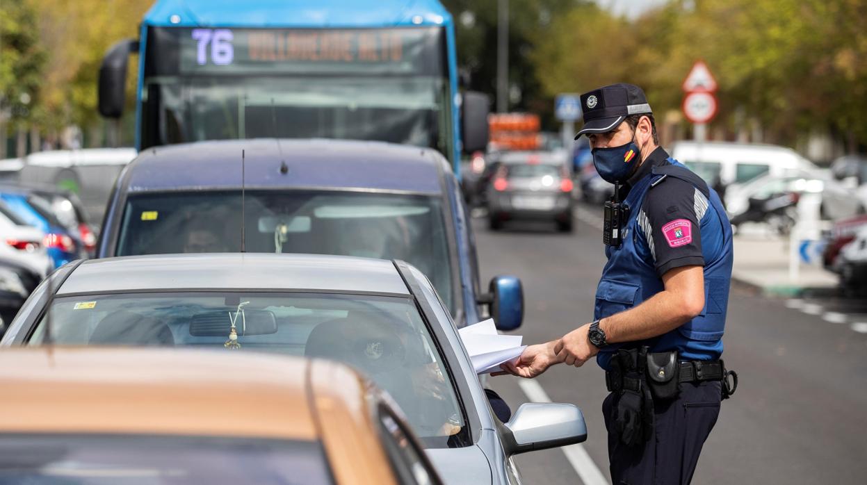 Un policía municipal revisa la documentación de un conductor en Madrid