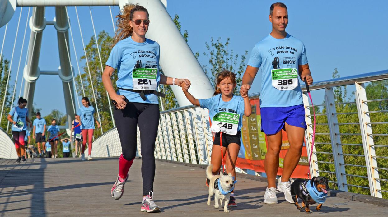 Una familia participa con sus mascotas en una edición anterior de la CAN-CARRERA de BIOPARC Valencia