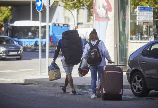 Dos personas, ayer por la tarde en Madrid, transportan grandes maletas