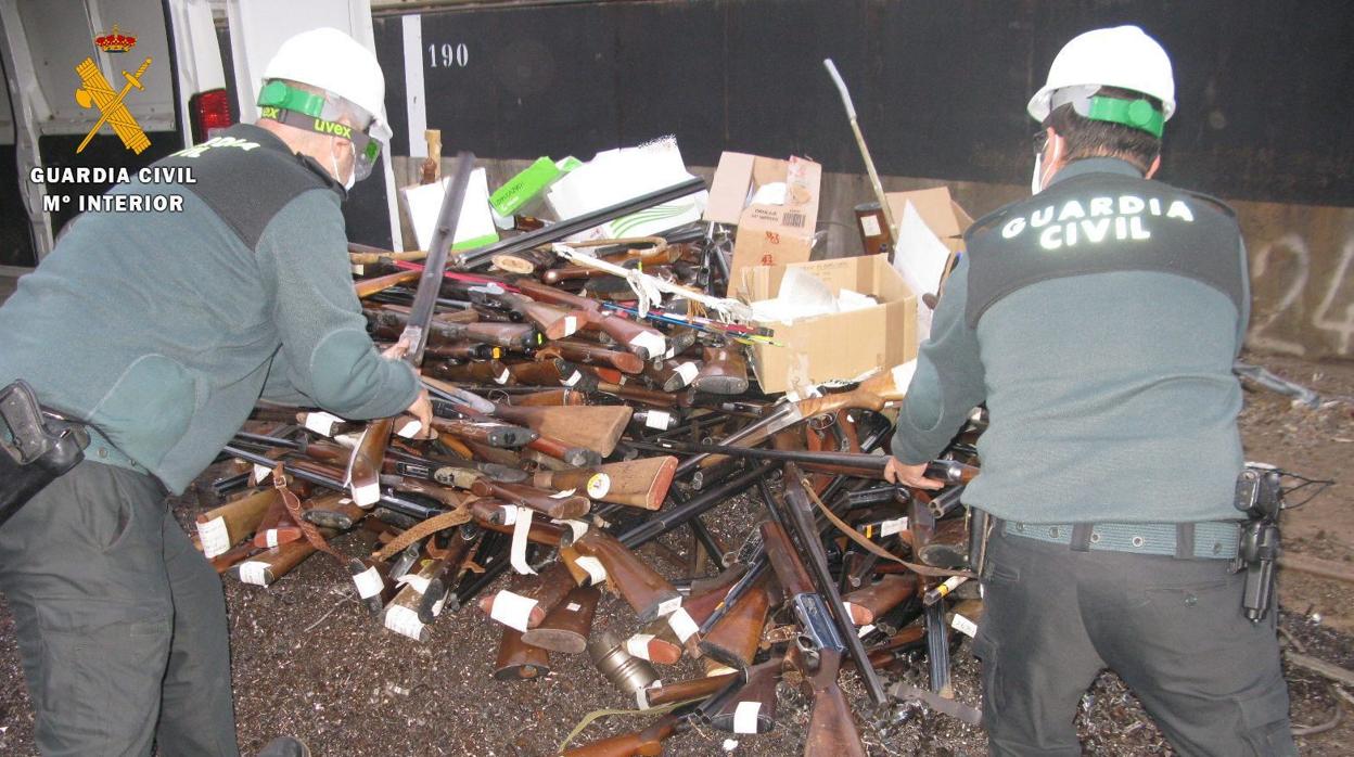 Dos agentes de la Guardia Civil, amontonando parte del arsenal poco antes de ser fundido para chatarra