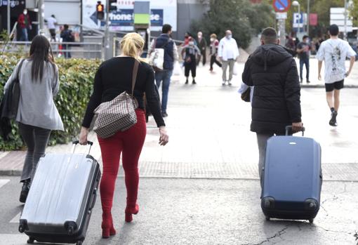 Dos viajeros arrastrando sus maletas, ayer, por la calle Alcalá