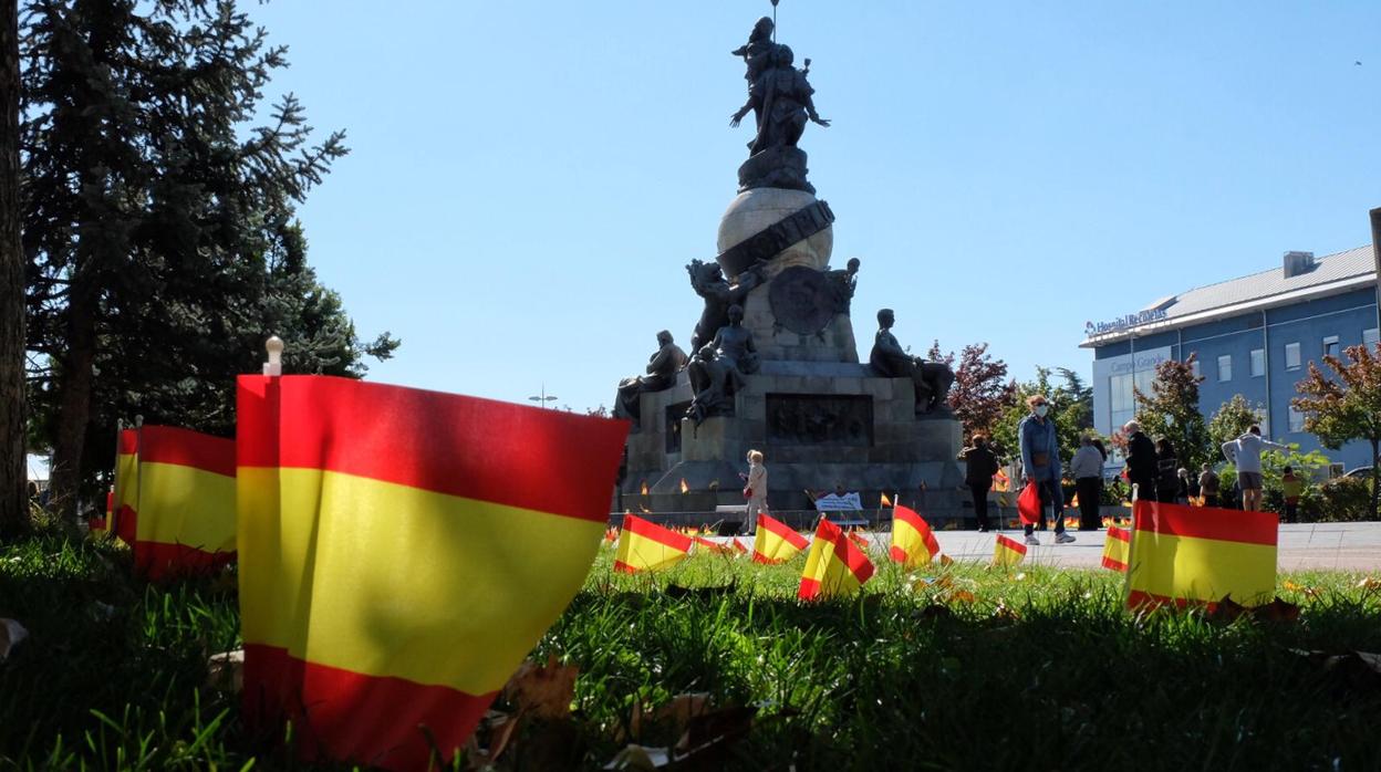 El monumento dedicado a Cristóbal Colón con banderas de España en recuerdo a las víctimas del coronavirus