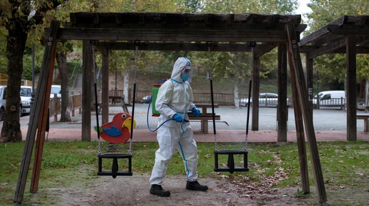 Un operario desinfectando un parque infantil en Orense