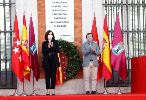 La presidenta regional Isabel Díaz Ayuso y el alcalde de la capital, José Luis Martínez-Almeida ante la placa que recuerda a las víctimas del Covid-19 en la Real Casa de Correos de Madrid