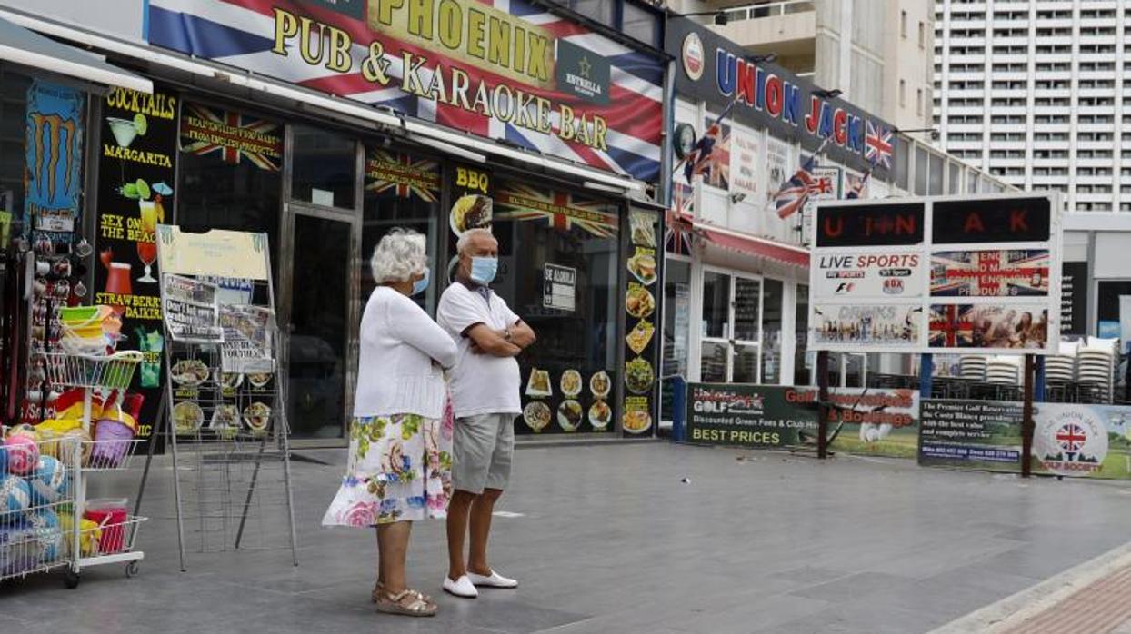 Dos turistas en una zona concurrida de Benidorm, ahora vacía por la pandemia