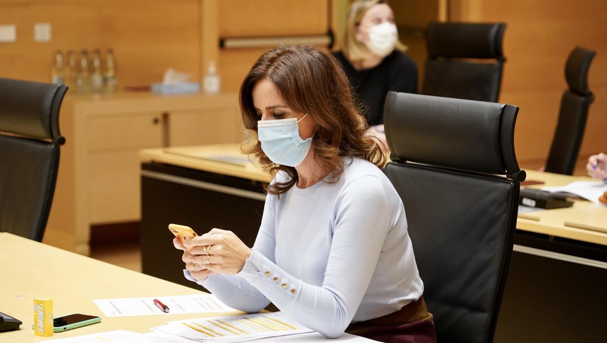 La consejera de Empleo, Ana Carlota Amigo, siguiendo el pleno desde una sala anexa antes de confinarse tras conocer el positivo en Covid de un contacto estrecho