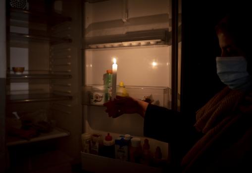 Amina enseña el interior de su nevera, provista con una vela