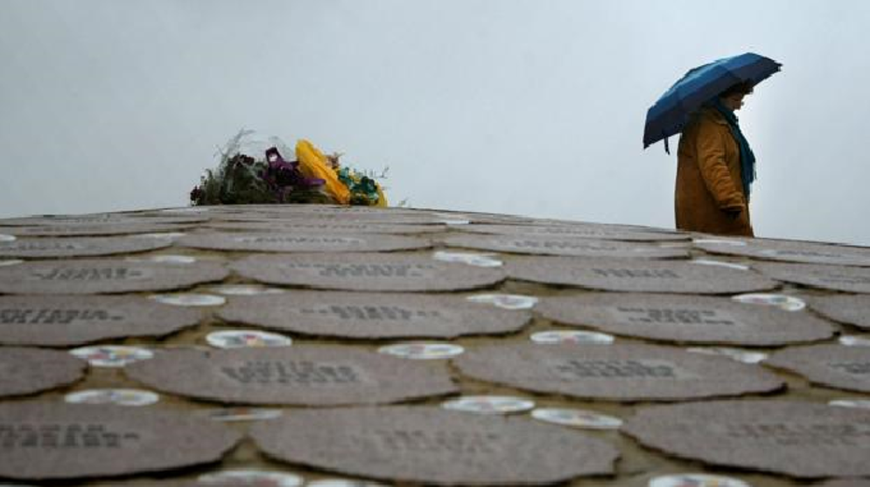 Una mujer busca el nombre de una víctima en el monumento de homenaje creado por el escultor vasco Agustin Ibarrola durante el acto de Covite, el 17 de diciembre de 2005 en los Jardines de Lakua, en Vitoria