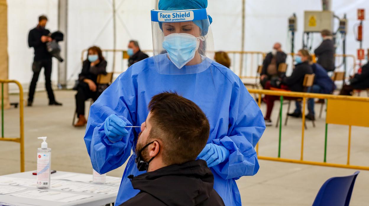 Una sanitaria realiza un test de coronavirus a un vecino de Madrid