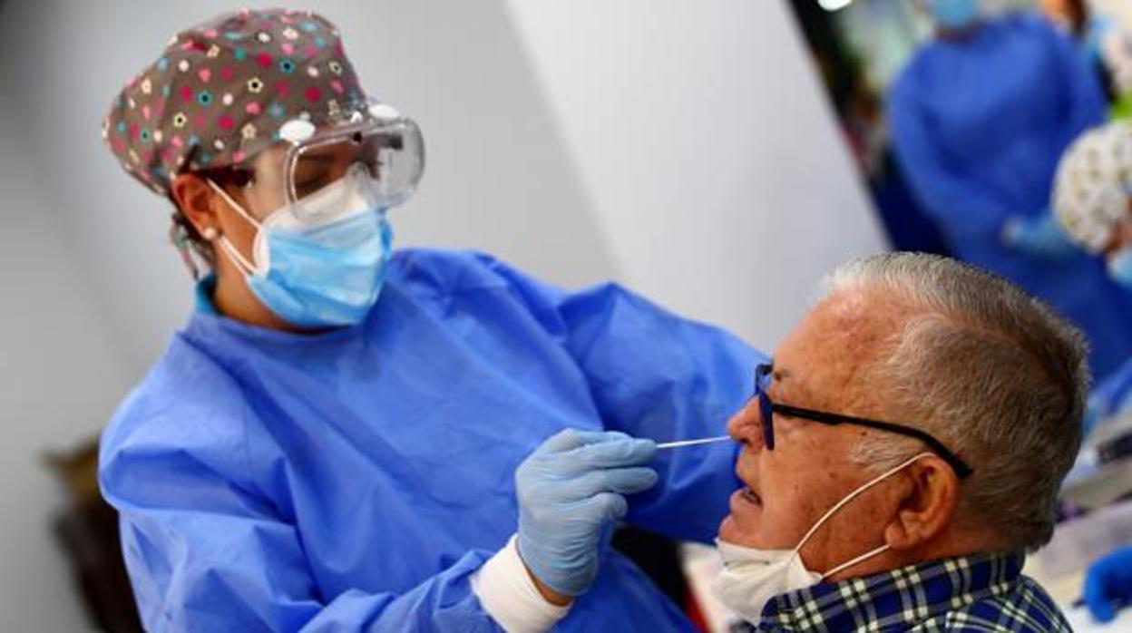 Una sanitaria realiza un test de antígenos a un vecino en Vallecas