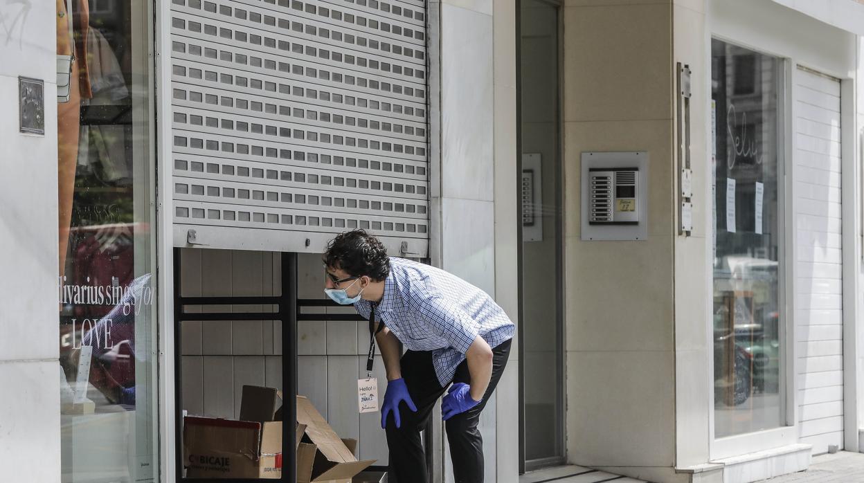 Imagen de archivo de un trabajador en la puerta de un comercio