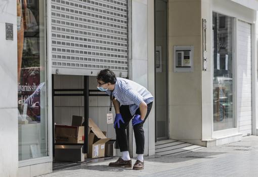 Imagen de archivo de un trabajador en la puerta de un comercio