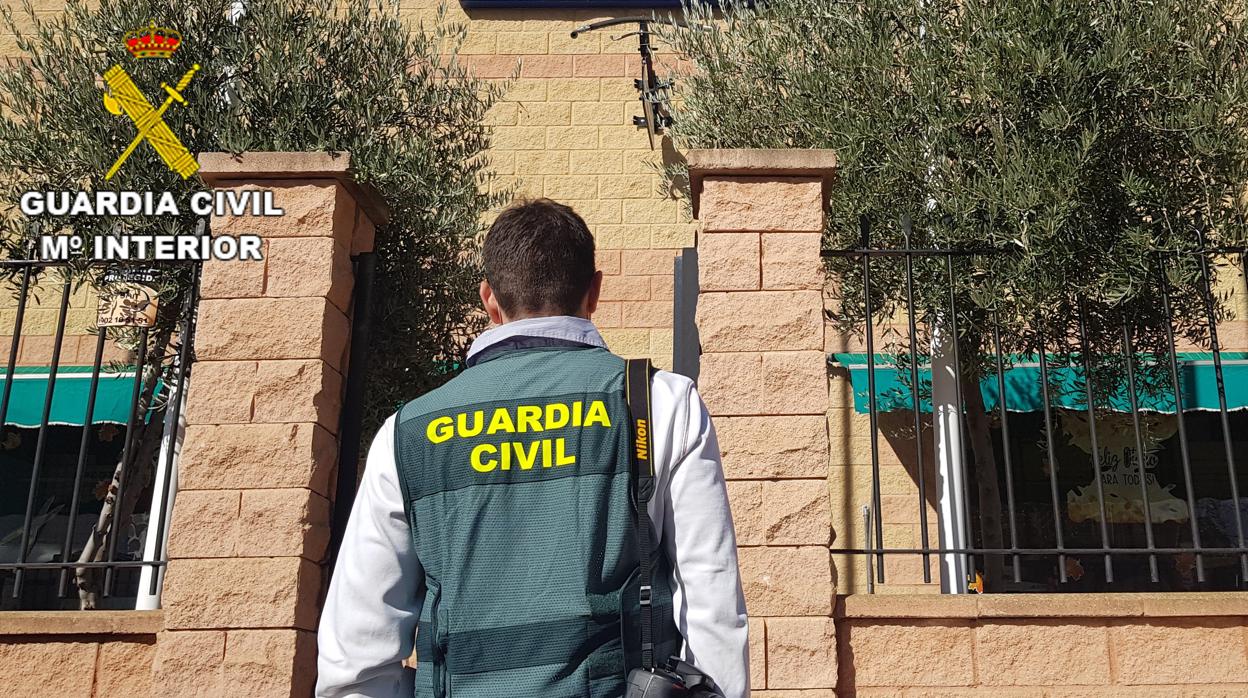 Un guardia civil delante de la ferretería asaltada