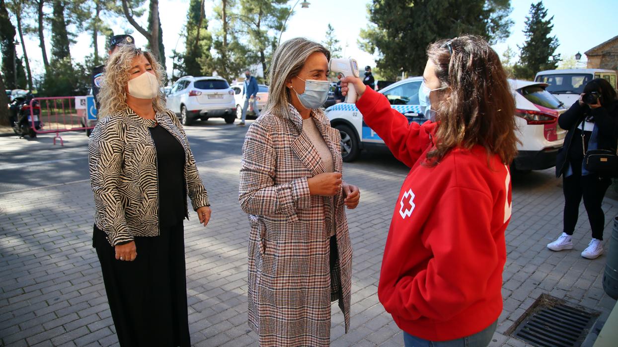 Una voluntaria de Cruz Roja toma la temperatura a Tolón y Medina a su llegada al cementerio