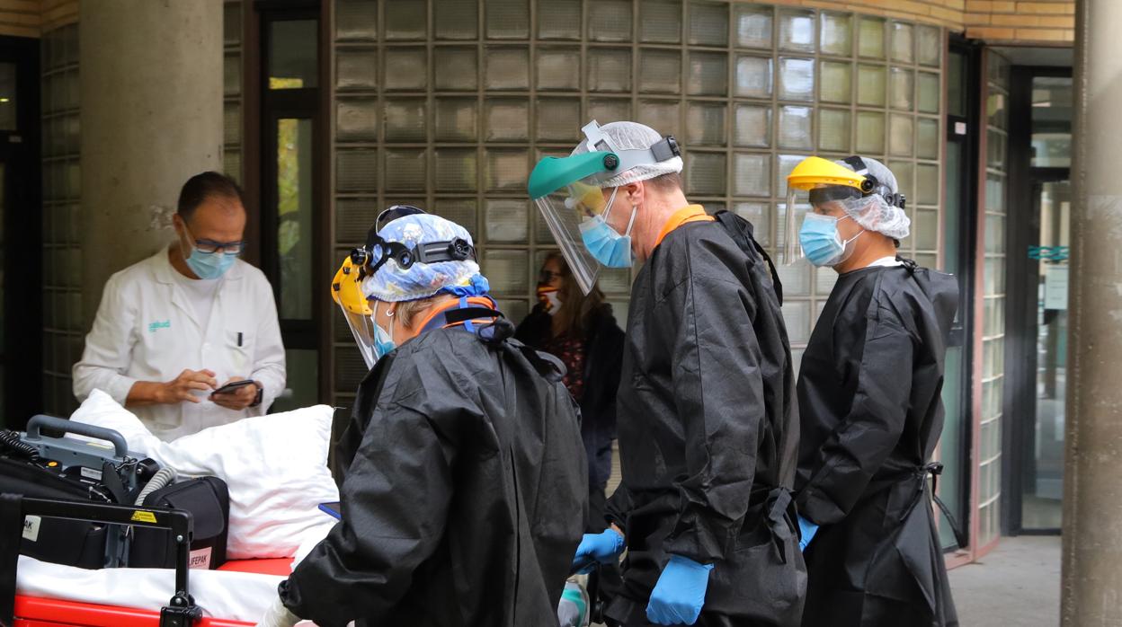 Sanitarios enfundados para no contagiarse de Covid, durante el traslado de un paciente en Zaragoza