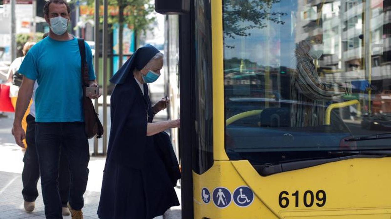 Una monja subiéndose a un bus urbano en Orense, una de las ciudades afectadas por las restricciones más duras del coronavirus