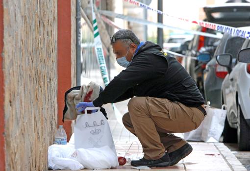 Imagen de un agente de la unidad de criminalística recogiendo la ropa de la joven agredida