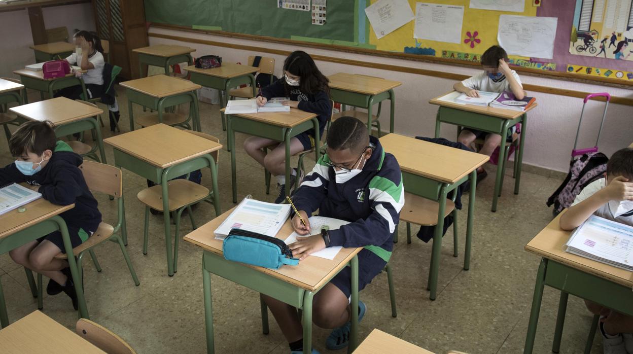 Alumnos en clase, con mascarillla y guardndo las distancias sociales