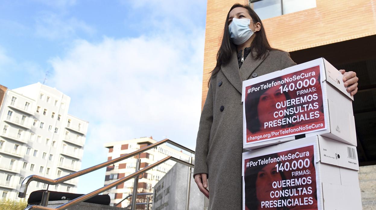 La hermana de una mujer fallecida por cáncer en Burgos, Lydia Sainz-Maza, acompañada por su marido, entrega 140.000 firmas recogidas a través de la plataforma Change.org para pedir la vuelta de las consultas presenciales