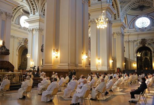 Sacerdotes siguiendo la ceremonia de toma de posesión del nuevo arzobispo de Zaragoza