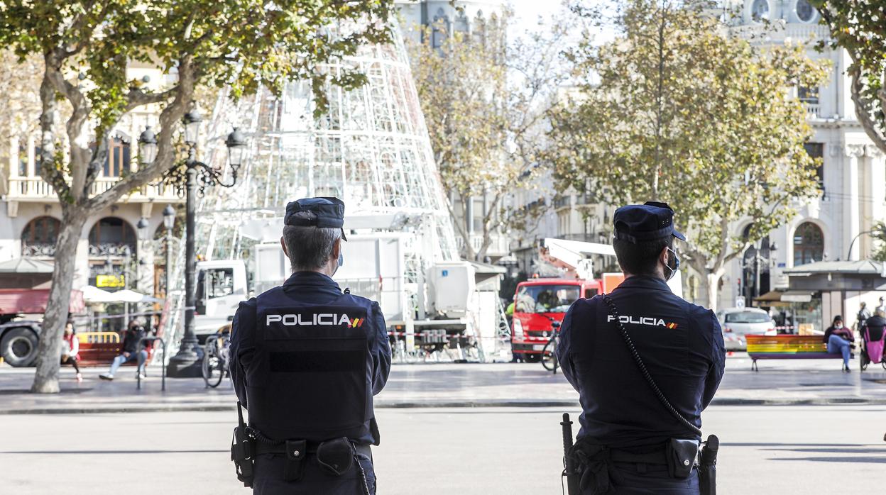 Imagen de agentes de la Policía Nacional frente al árbol de Navidad en la plaza del Ayuntamiento de Valencia