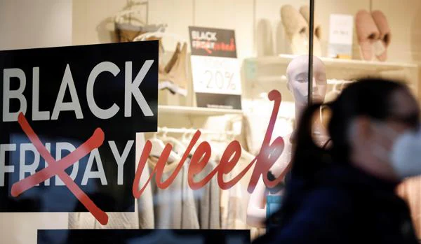 Una mujer pasa ante un escaparate de un comercio con promociones del «Black Friday» en Valencia