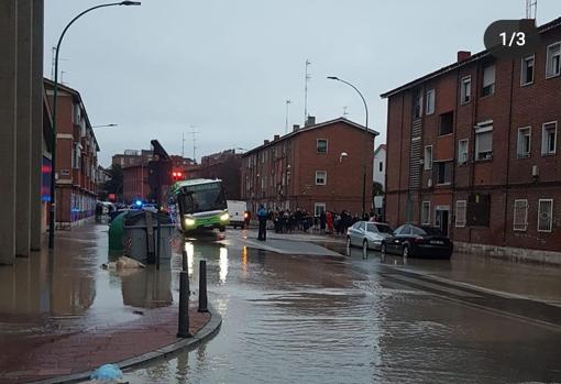 Calle anegada y autobús urbano de Valladolid atascado en un socavón