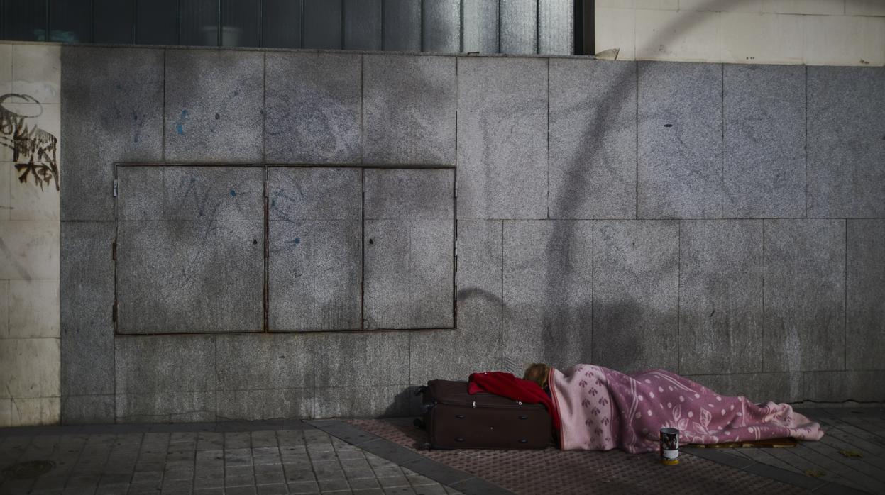 Un mendigo, en la acera de una calle del centro de Madrid