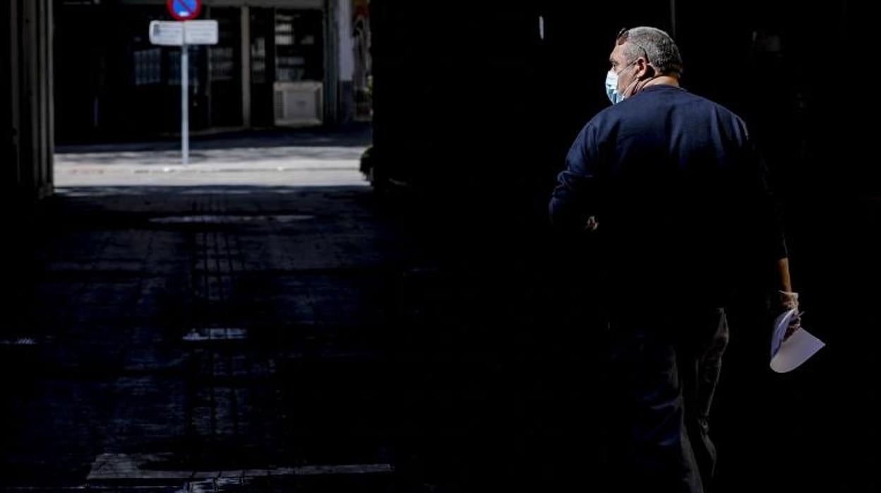 Imagen de archivo de un hombre paseando con mascarilla por Valencia