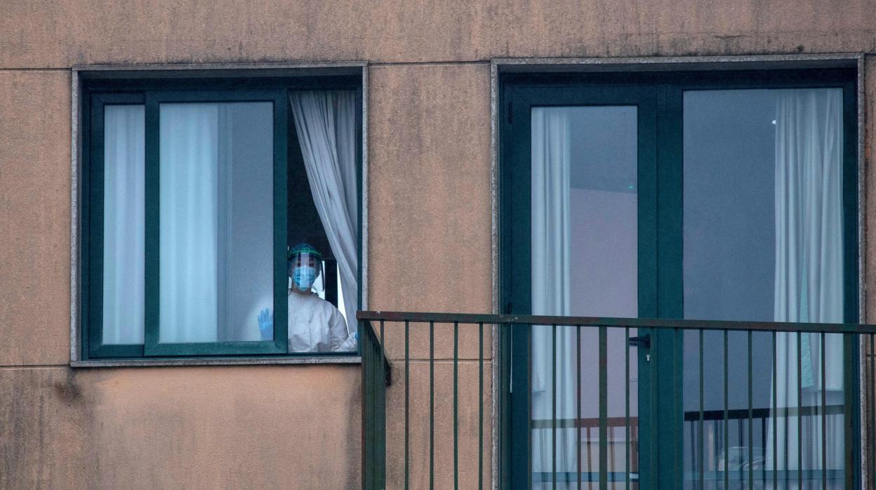 Una trabajadora sanitaria observa desde el interior de una residencia en San Cristovo de Cea (Orense)