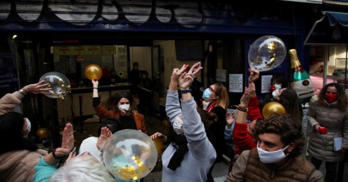 Trabajadores de una administración de lotería celebran los premios del sorteo de Navidad