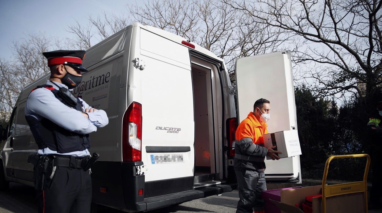 Transportistas con cajas con la vacuna de Pfizer llegan a Hospitalet para la vacunación, el domingo.