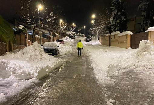 Rafael, con una chaqueta de la UME, pasea esta noche por una calle ya limpia por los vecinos