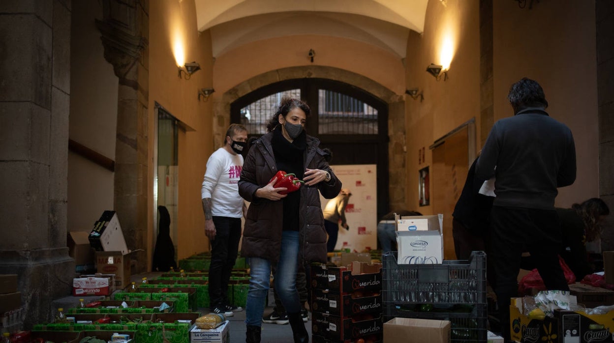 Varios voluntarios de la asociación Actúa Ayuda Alimenta (AAA) preparan cestas de alimentos para trabajadores del sector cultural, en Barcelona