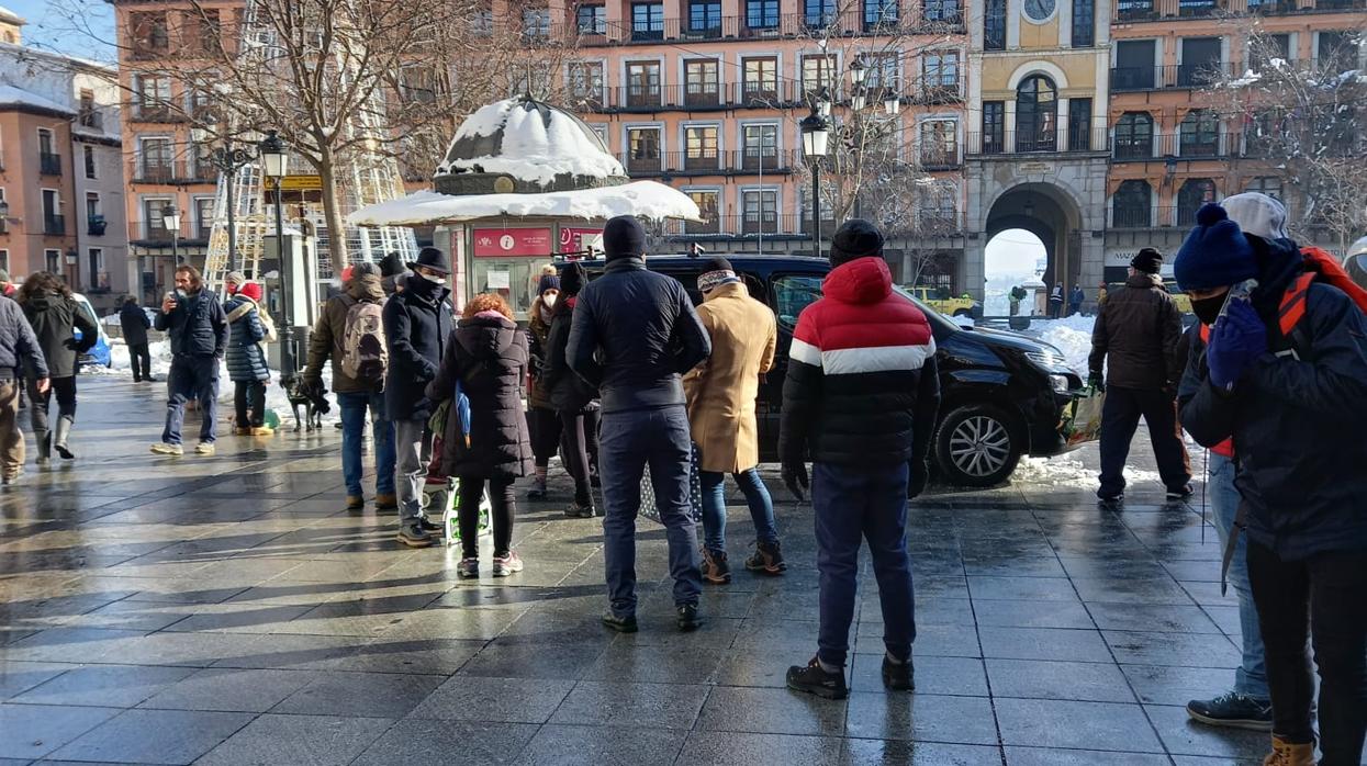 Algunos vecinos aguardan en fila en la céntrica plaza de Zocodover para recoger sal