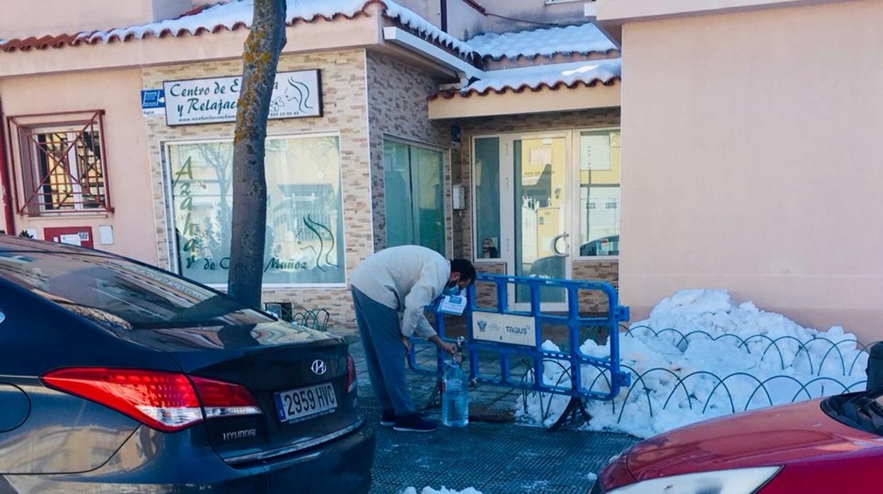 Recogiendo agua potable en la calle Alemania, en donde se han producido numerosos cortes de suministros en las viviendas por culpa de la congelación de las tuberías