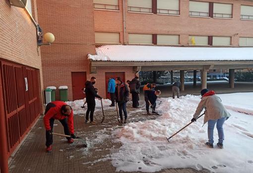 Profesores y padres limpian de nieve el colegio