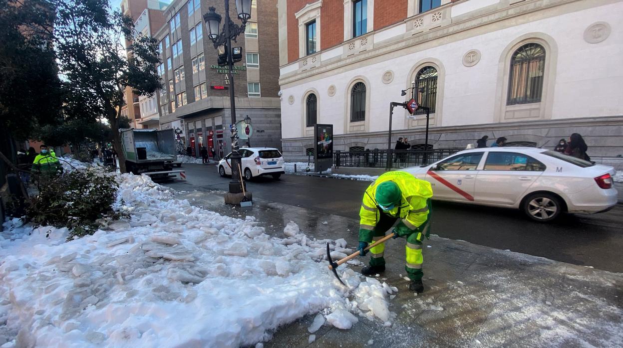 Un operario de limpieza retira hielo y nieve tras la gran nevada