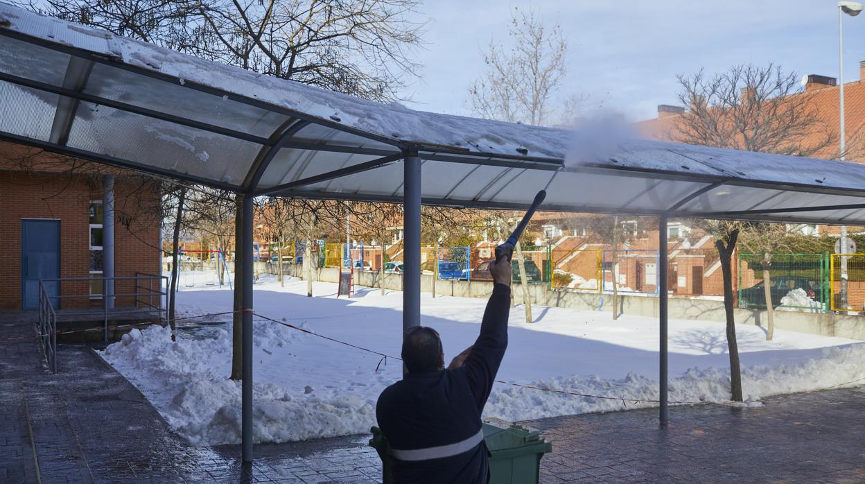 Un hombre limpia la nieve en un centro educativo de Colmenar Viejo